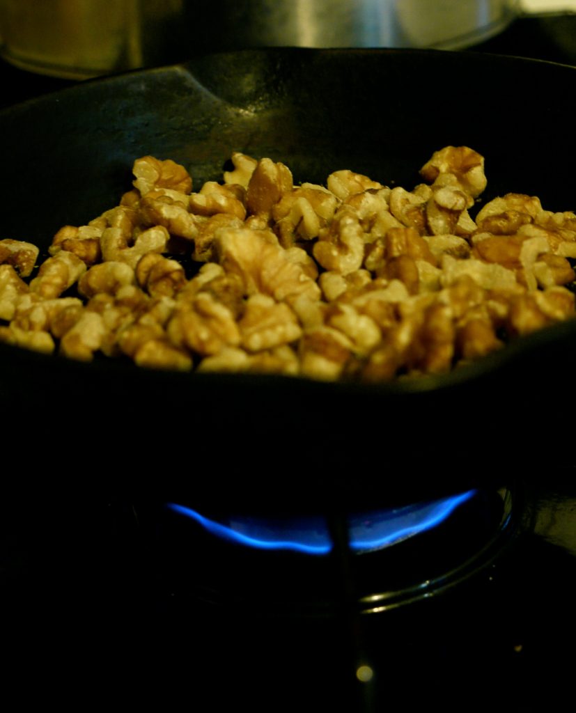toasting walnuts in a cast iron skillet to use in maple walnut topping for ice cream